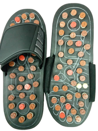 A pair of black massage slippers with acupressure nodes and nubs on the sole, designed for targeted foot massage.