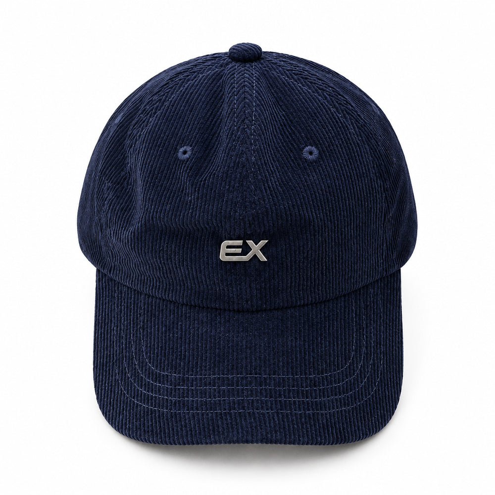 A dark navy blue corduroy baseball cap with a small silver 'EX' logo on the front, displayed on a light beige fabric background.