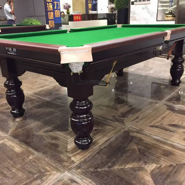 Snooker table with green felt surface on a tiled floor