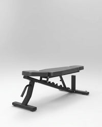 A black adjustable weight bench with a padded seat and backrest, shown at an angle on a light gray studio background.