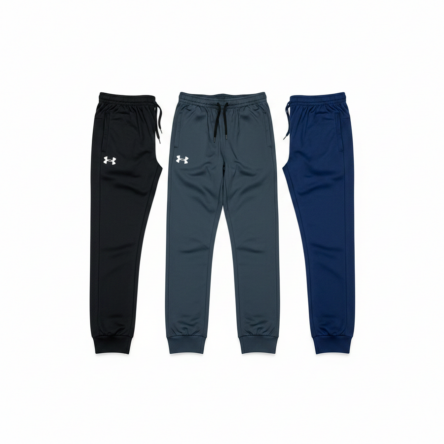 Three pairs of Under Armour jogger sweatpants are displayed side-by-side against a plain white background. From left to right, the colors are black, a dark slate gray, and navy blue.