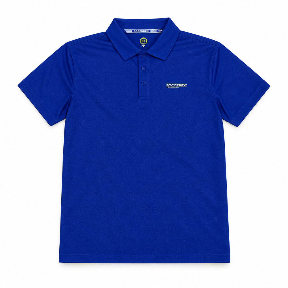 A royal blue short-sleeve polo shirt laid flat on a beige surface, with a hangtag still attached near the collar and a small white embroidered logo on the left chest.