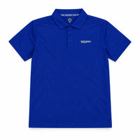 A royal blue short-sleeve polo shirt laid flat on a beige surface, with a hangtag still attached near the collar and a small white embroidered logo on the left chest.
