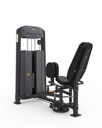 An hip abductor machine gym machine in black and dark gray, shown from a three-quarter angle on a solid white background.